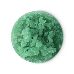 A LUSH After Dinner Mint lip scrub is a solid, circular product made of chunky green sugar crystals. The scrub, which has a rough, textured surface, is placed on a light grey background.
