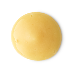 A smooth, circular dollop of creamy yellow shower gel with a glossy finish. The thick, opaque liquid features tiny air bubbles and is centered against a clean, neutral grey background.