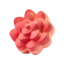 Comforter Rose. A vibrant coral-coloured bath bomb sculpted into the shape of a blooming rose with thick, rounded petals. The textured surface has a matte finish with subtle peach-coloured highlights.