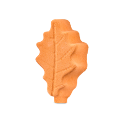 An orange Lush bath bomb shaped like an oak leaf, detailed with embossed veins.