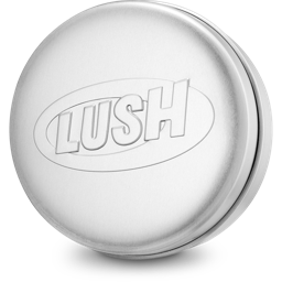 A round, matte silver aluminium shampoo bar tin product holder. The lid features the "LUSH" brand name debossed inside an oval outline in the centre, creating a clean, metallic texture.
