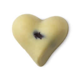 Soft Coeur. A creamy, ivory-coloured, heart-shaped massage bar. There is a small bit of brown vanilla just visible in the centre of the product. 