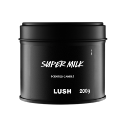 A black product shot of the Super Milk Scented Candle in a round, matte black tin with a fitted lid. The label features the product name in a white, handwritten-style font, with "SCENTED CANDLE" and "LUSH 200g" below it.
