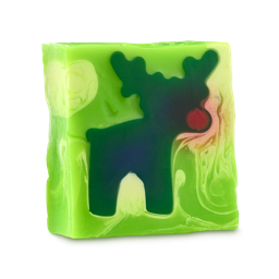 The Most Famous Reindeer of All. A square block of lime green soap. Inset into the centre is a dark green reindeer silhouette with large antlers and a distinct red nose, surrounded by subtle swirls of lighter green.