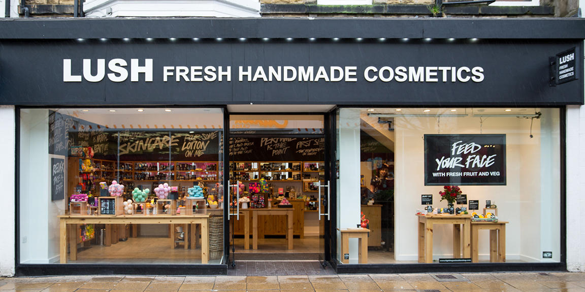 A photo of our shop front: a windowed store front with fresh products on display on top of wooden benches.