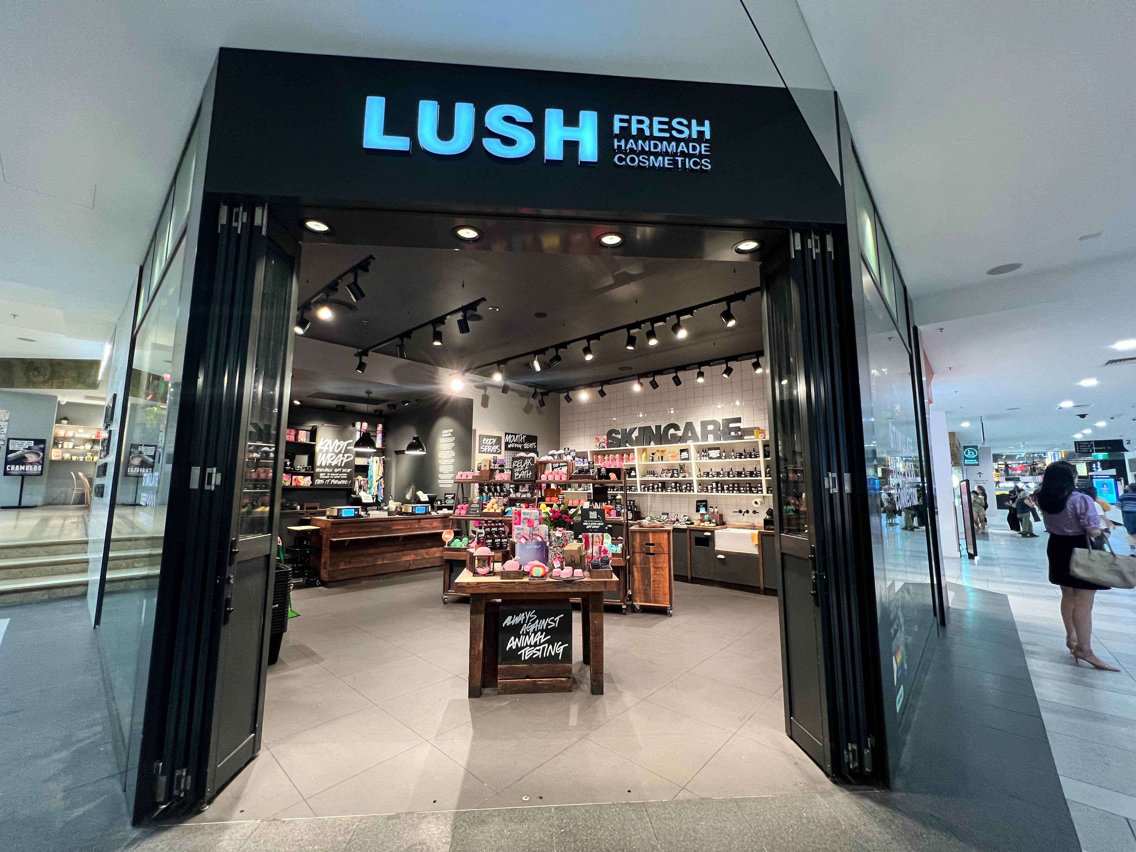 Large open doorway leading into the shop. Illuminated sign above doorway Lush Fresh Handmade Cosmetics.