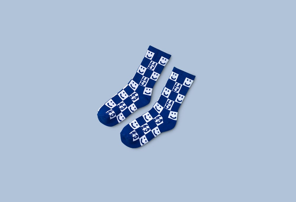 Blue and white checkered socks with happy faces on them on a light blue background.