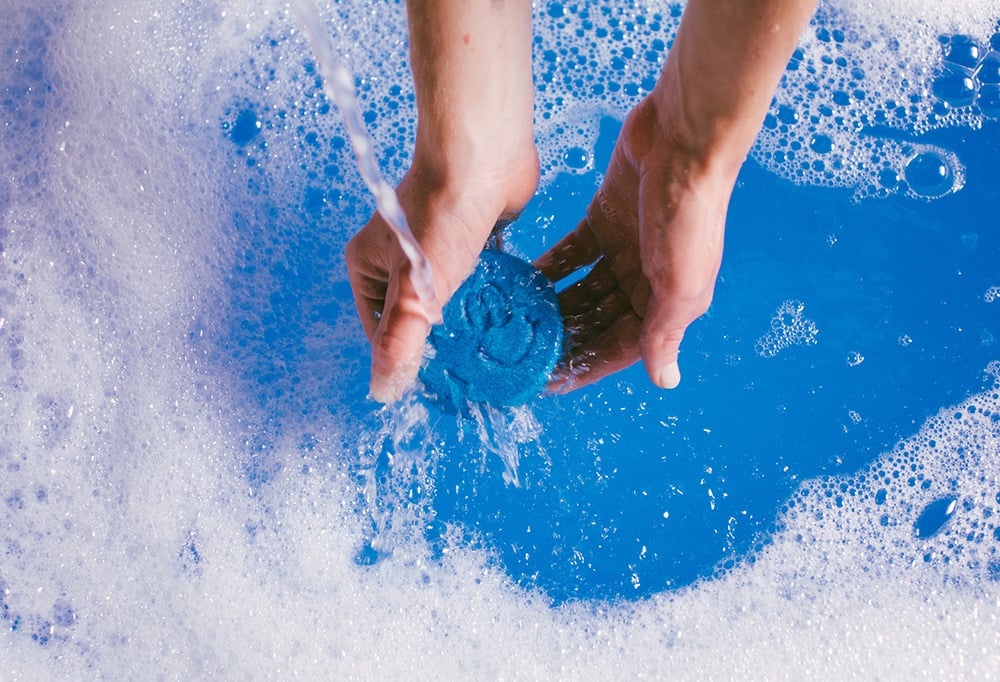 Running water is poured onto Bubbly Buddy over blue bubbly water.