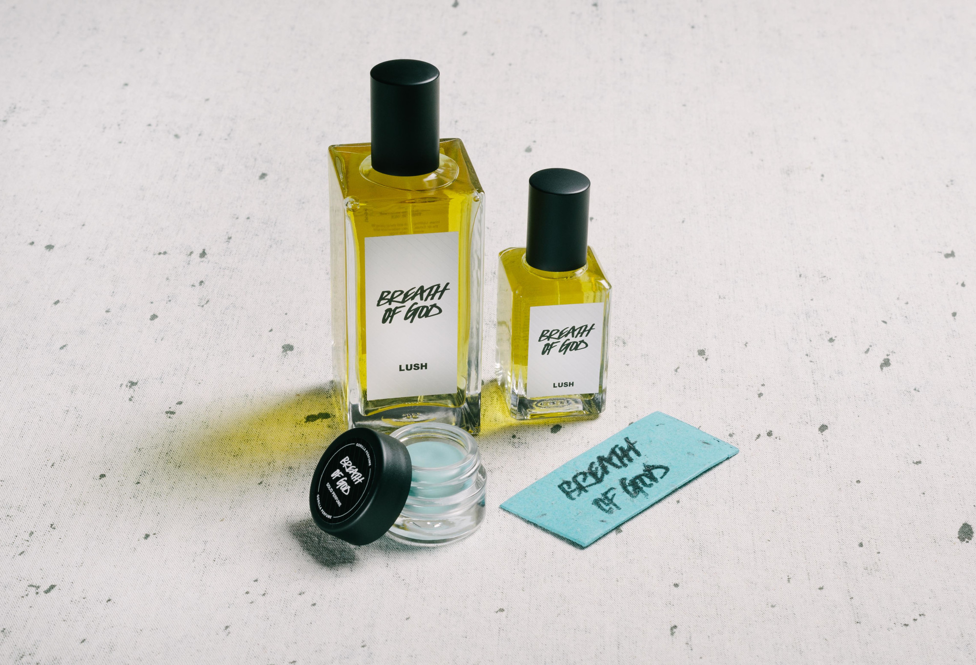The whole Breath of God fragrance collection is displayed on a white surface, flecked with grey.