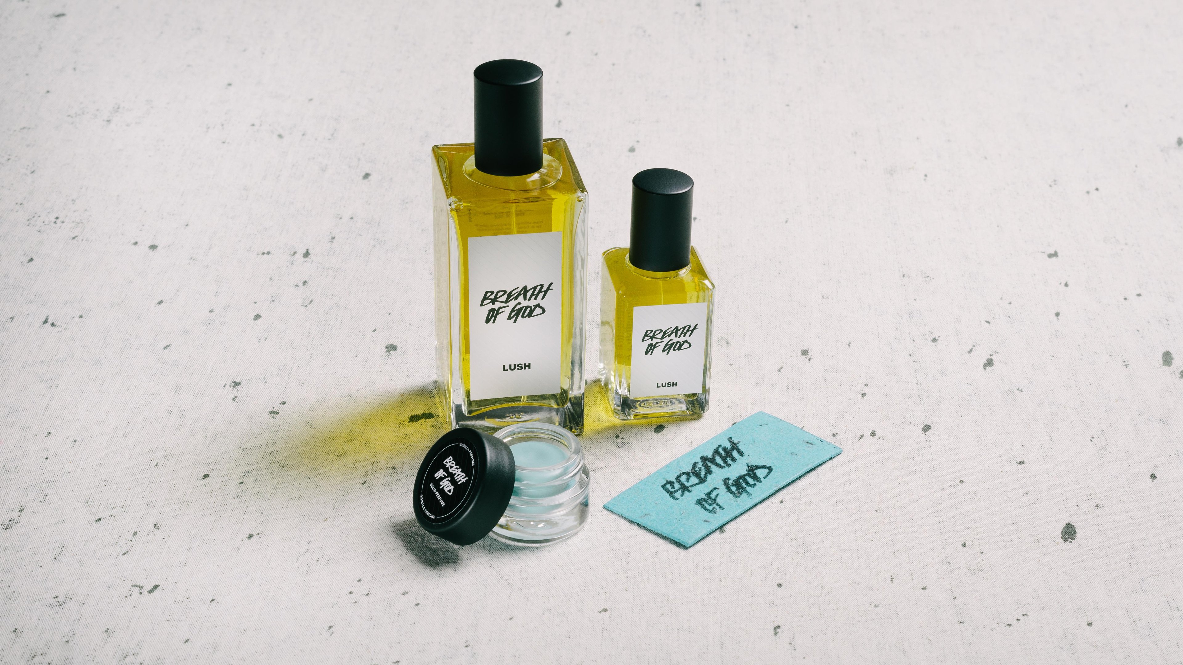 The whole Breath of God fragrance collection is displayed on a white surface, flecked with grey.