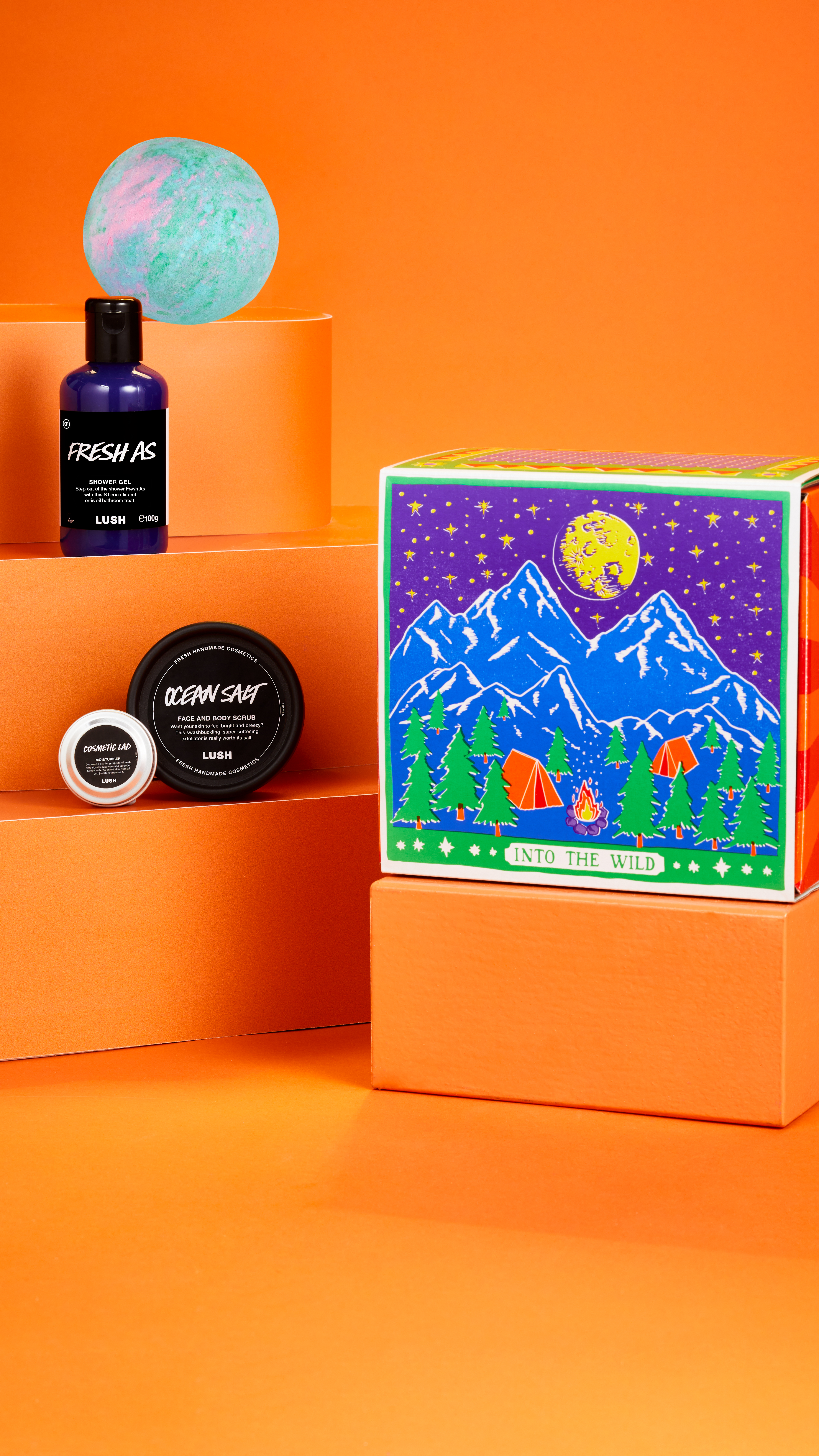 Into The Wild Gift on a bright orange background showing products stacked on tiered ledges with box lid on the right.