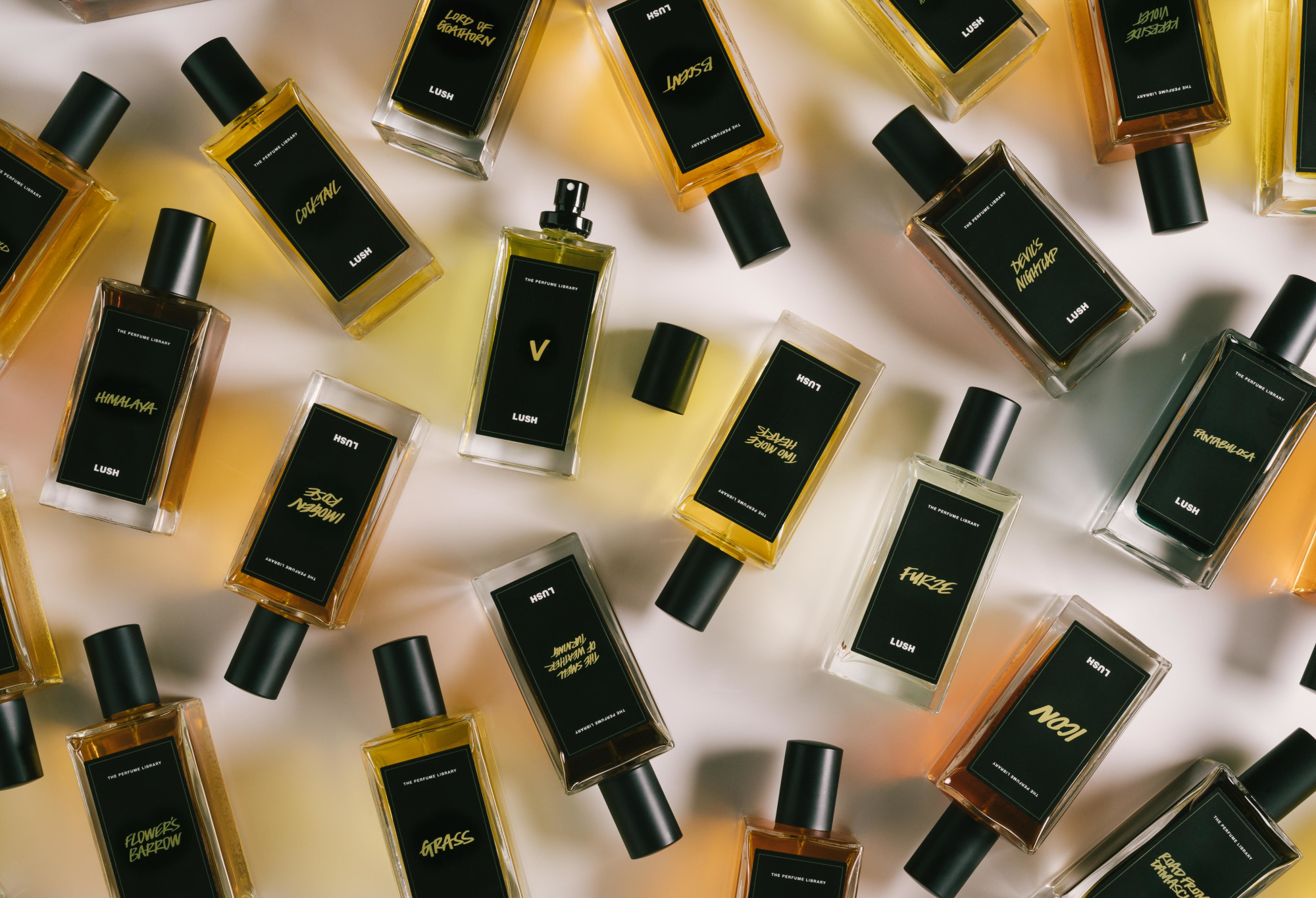 A number of black label perfume bottles are arranged randomly, with V in the centre, lid off, ready to spritz.