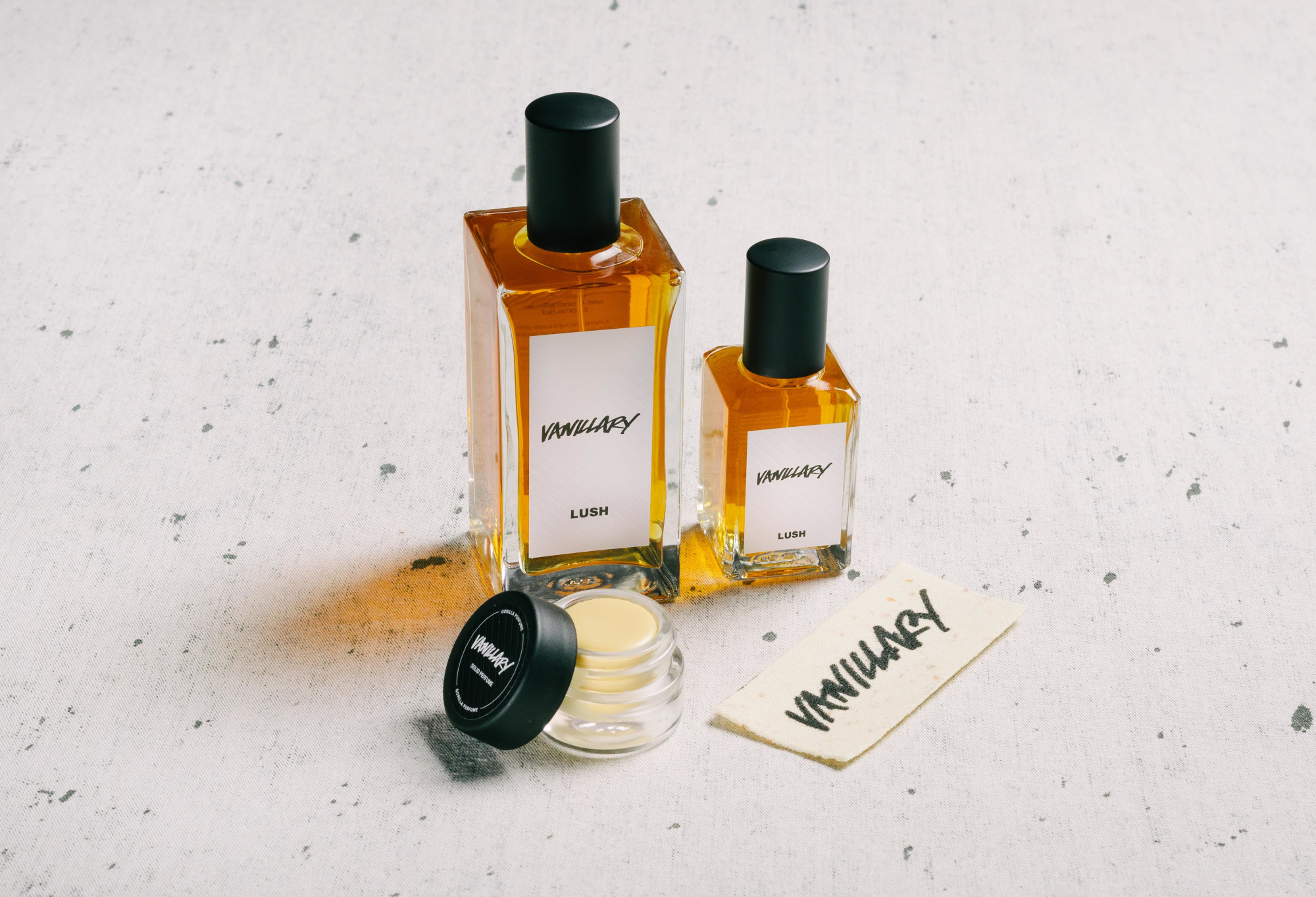 The whole Vanillary fragrance collection is displayed on a white surface, flecked with grey.