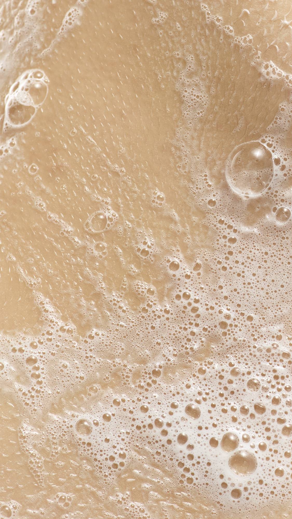 A close-up of white, soapy lather and bubbles from Waiter! There's A Fly In My Soap on a person's skin.