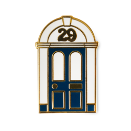 29 High Street. An enamel pin shaped like a traditional doorway with a navy-blue door and white surround, accented by gold-coloured metal edges. The number '29' is featured in gold within the arched window at the top