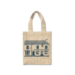 29 High Street. A cream-coloured canvas tote bag featuring a navy-blue line drawing of the original, traditional two-storey 29 High Street LUSH shop facade. The illustration shows detailed windows and a shop sign.