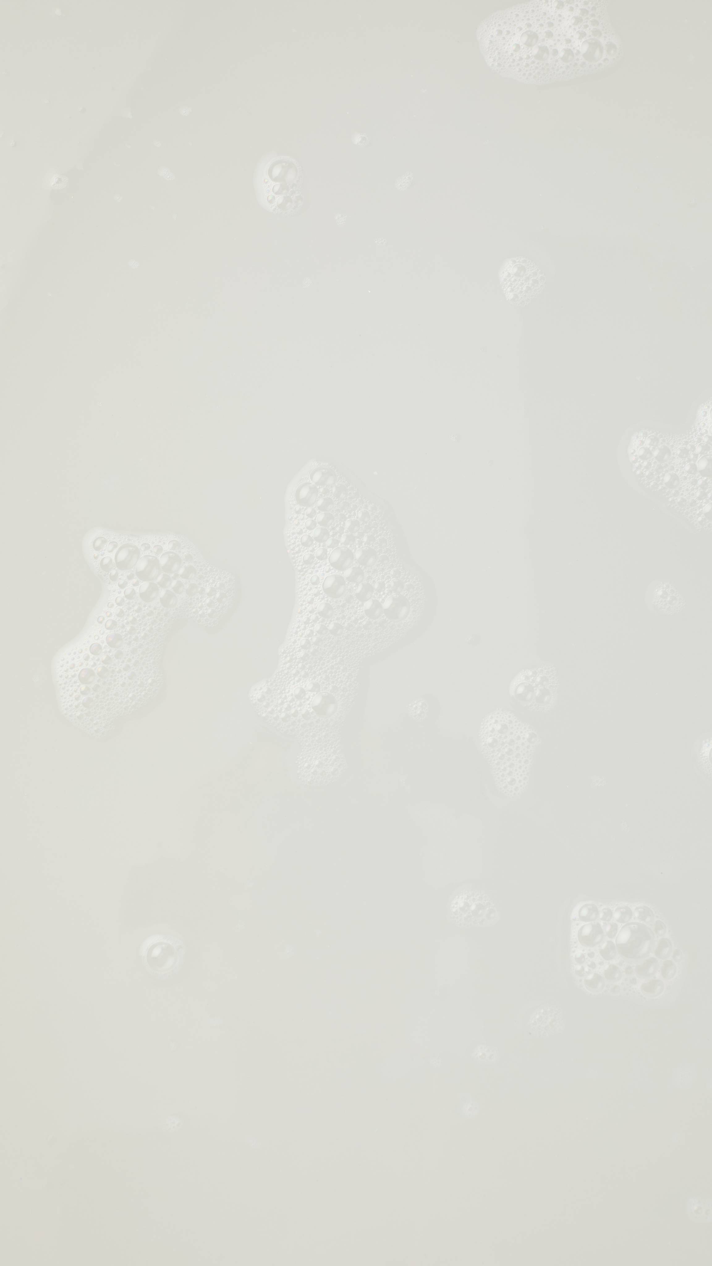 The image shows an aerial view of the bath water after using the Lush Snowing bath oil. The clear water has flecks of glitter throughout. 