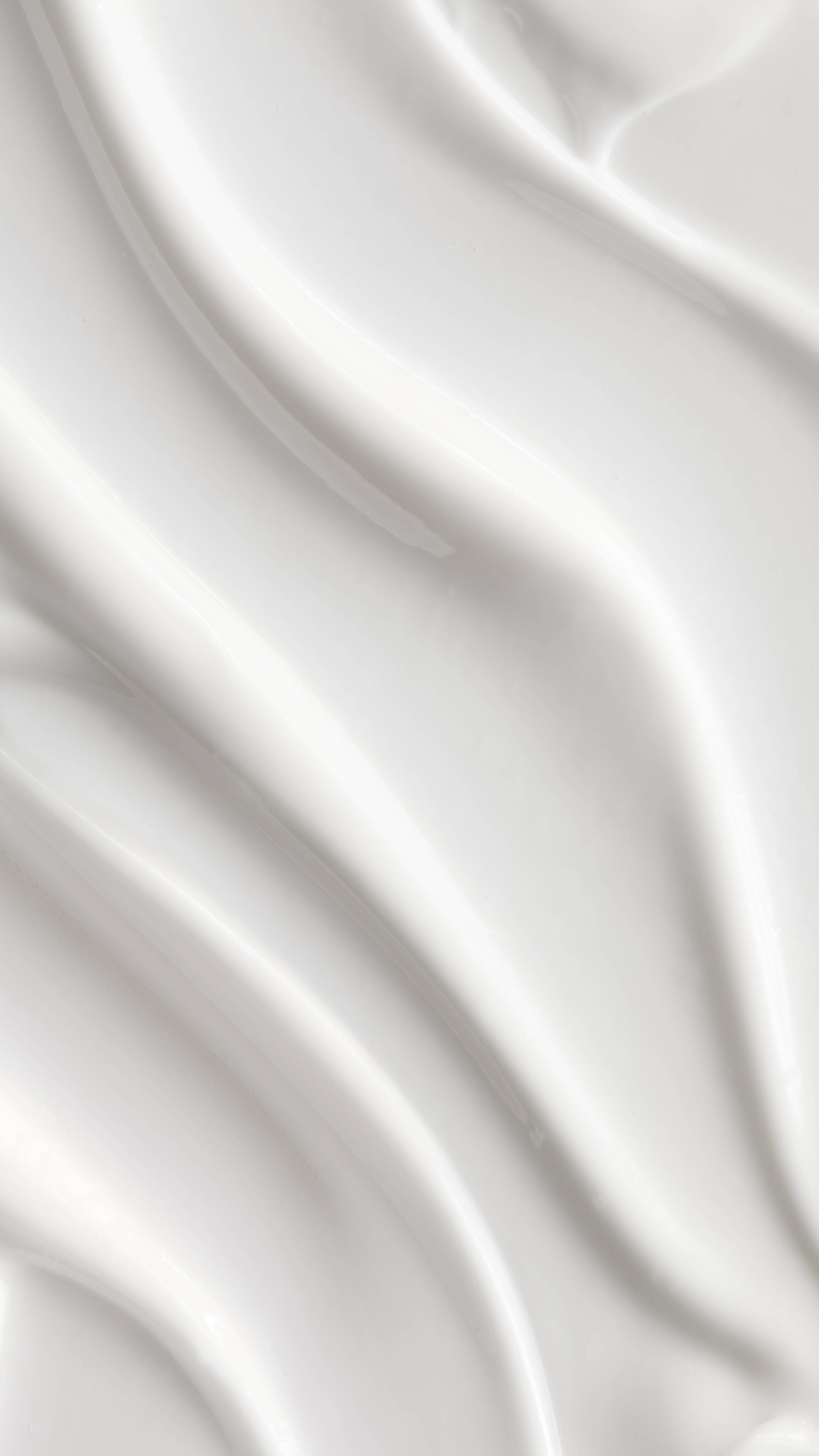 A close-up of a Celebrate body lotion swirled into soft, textured peaks and valleys. The smooth, shiny surface reflects light, creating a luxurious and clean look