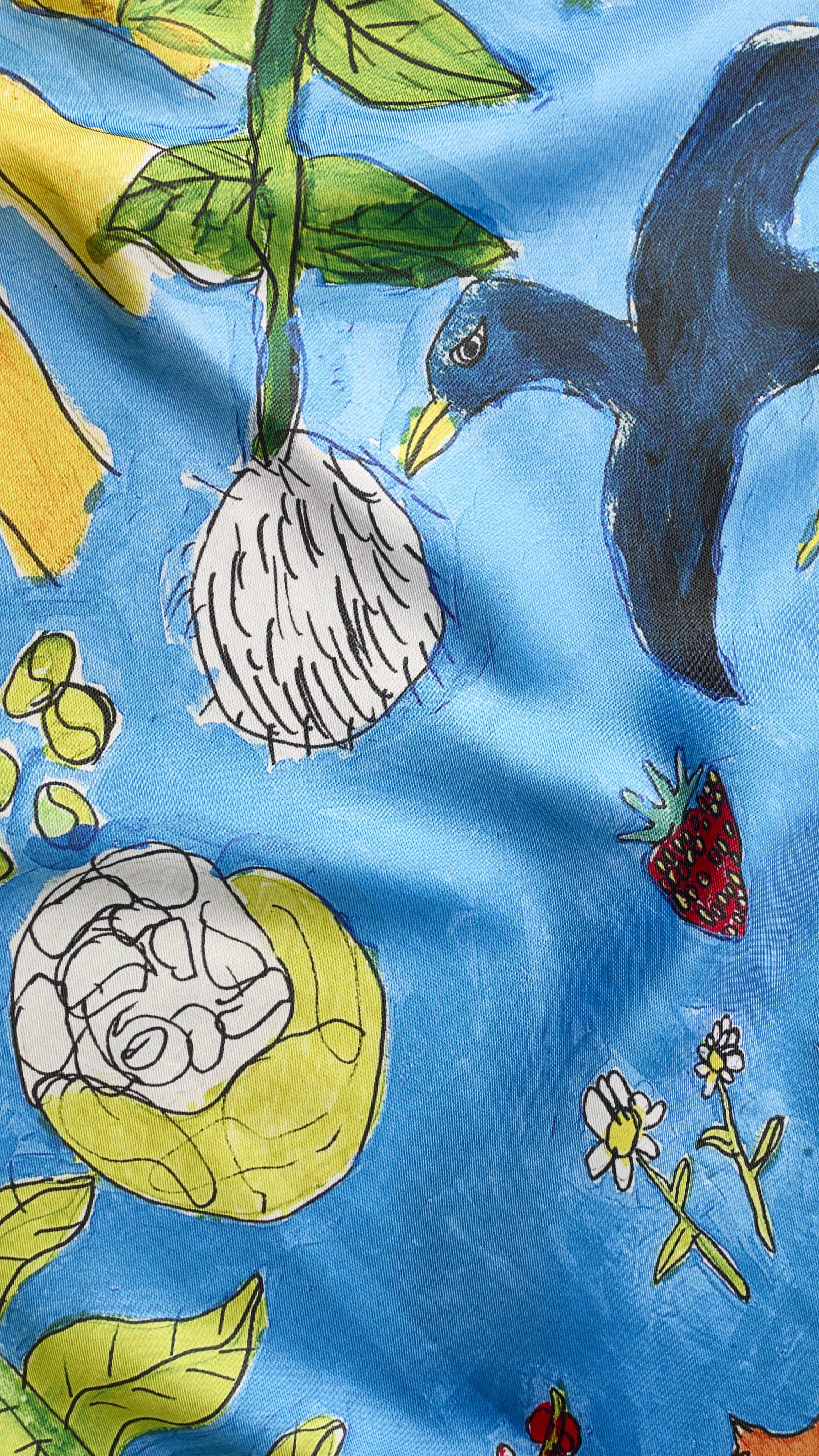 A super close-up texture shot of the "Garden Mural" fabric knot wrap. The image focuses on the soft texture of the knot wrap material and the vibrancy of the colours in the bright, nature design.