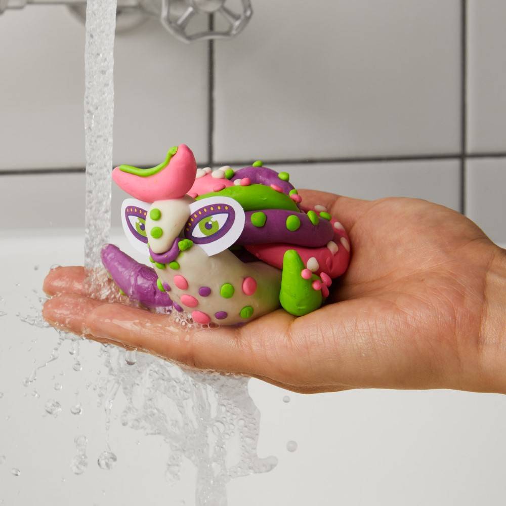 The Alebrije fun product has been moulded into an abstract, colourful turtle-like character being held under running water. 