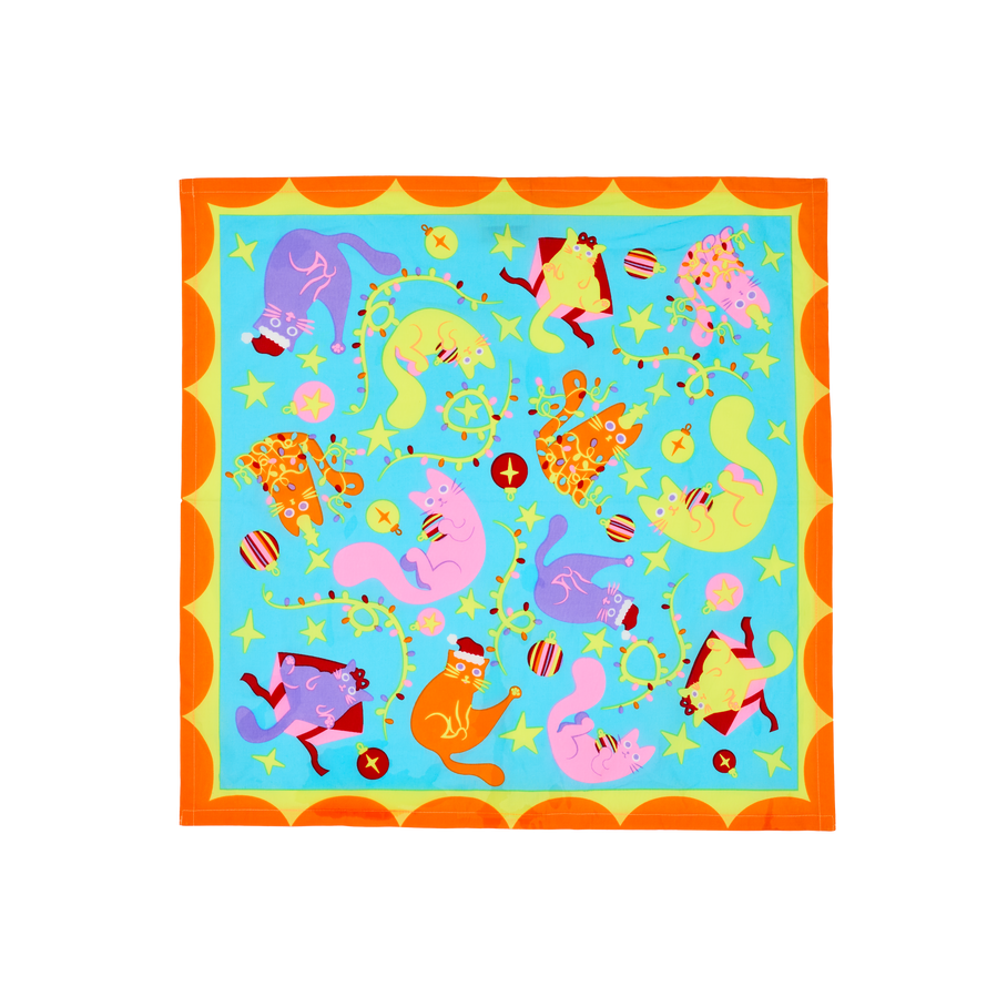 Purrrfect Christmas. A square, fabric knot wrap with an orange, scalloped border. The central design shows multiple, colourful cats in Christmas-themed scenarios, including playing with fairy lights, wearing a Santa hat, and in a box. 