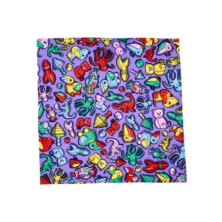 Vintage Toys. A square, fabric knot wrap with a purple background and a collage of vibrantly-coloured retro childhood toys, including rockets, spinning tops, teddy bears, wooden ducks, dice, wind-up toys and more. 