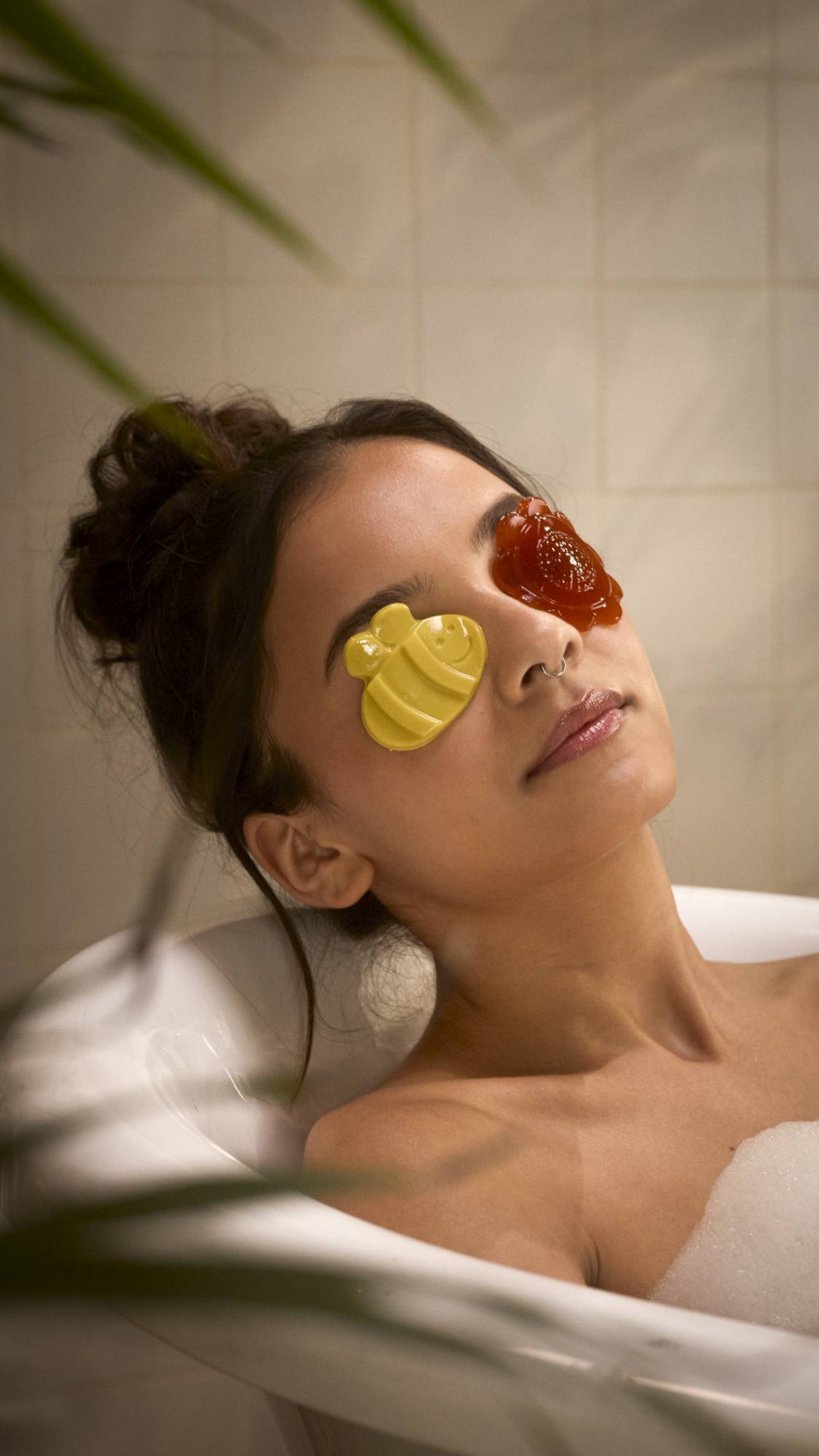 The image shows the model laid back in the bathtub with the Flight Of The Bumblebees eye pads over their eyes 