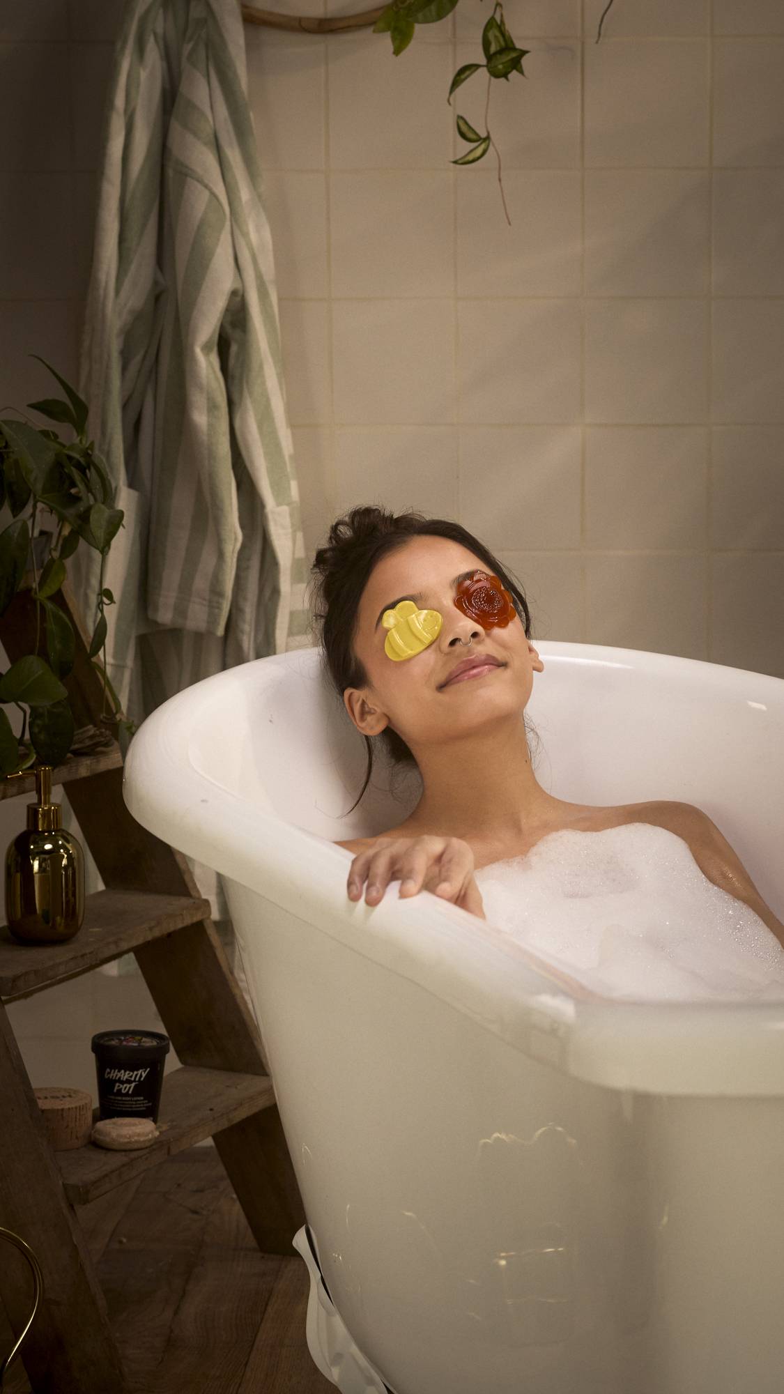 The image shows the model laid back in the bathtub with the Flight Of The Bumblebees eye pads over their eyes 