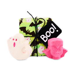 The image shows the Boo gift set. A green, ghost-and-bat-patterned box with a 'Boo!' tag sits behind a white ghost bath bomb with pink features and a vibrant pink Dracula head-shaped product. 