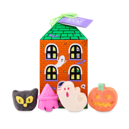 The image shows a 'HAUNTED HOUSE' gift box, shaped like a house with a green roof and orange brick walls. Four Halloween bath products sit in front: a black cat, a pink witch's head, a white ghost, and an orange pumpkin.