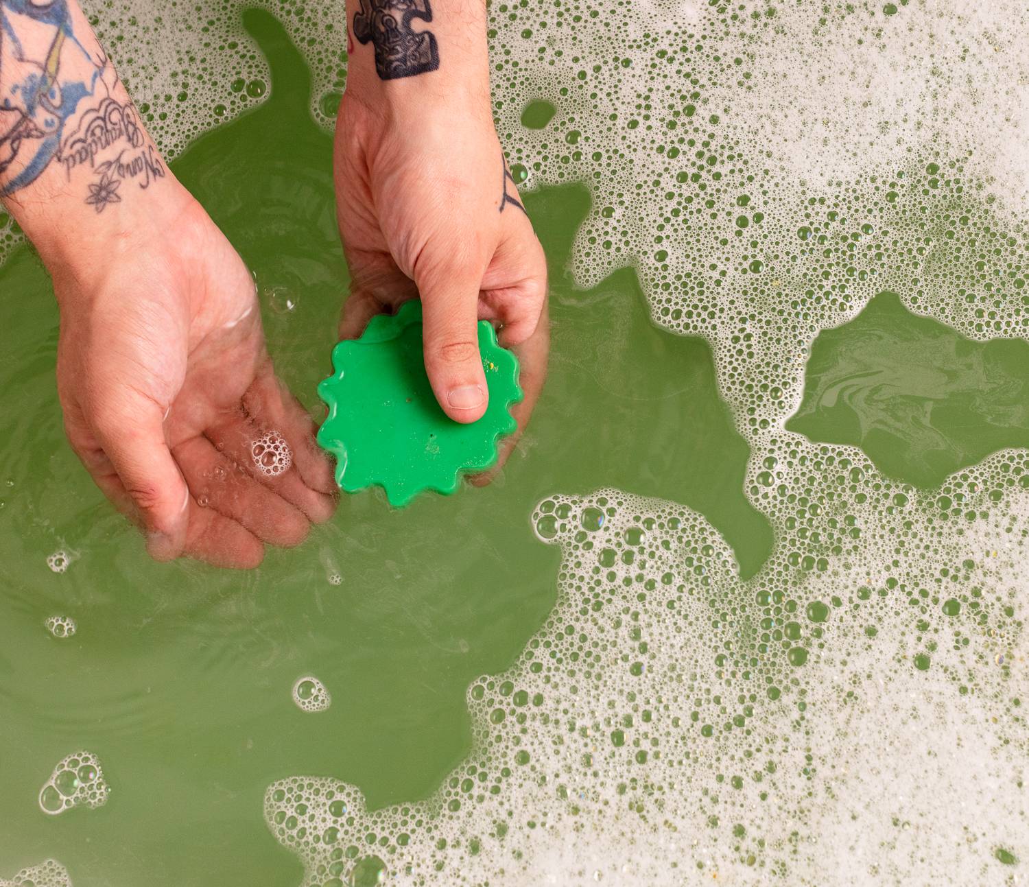 Image shows the model using the lettuce-shaped soap in the bath water surrounded by bubbles.