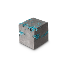 Diamond Ore Block. A rough-edged, cube-shaped bath bomb in a stone grey colour. There are flecks of blue, shimmering salts just visible throughout. 