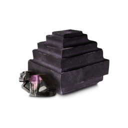 Ender Dragon Egg. A bath bomb shaped like a pixelated egg. It is a deep purple, almost black colour with flecks of pink. There is a similarly-coloured pixel-style, dragon-shaped soap in front. 