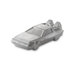OUTATIME. A shimmering, silver bath bomb shaped like a futuristic, angular car reminiscent of a DeLorean from the nostalgic nineties films, "Back To The Future". The product has a metallic glint, and the car features detailed windows and rear fins.