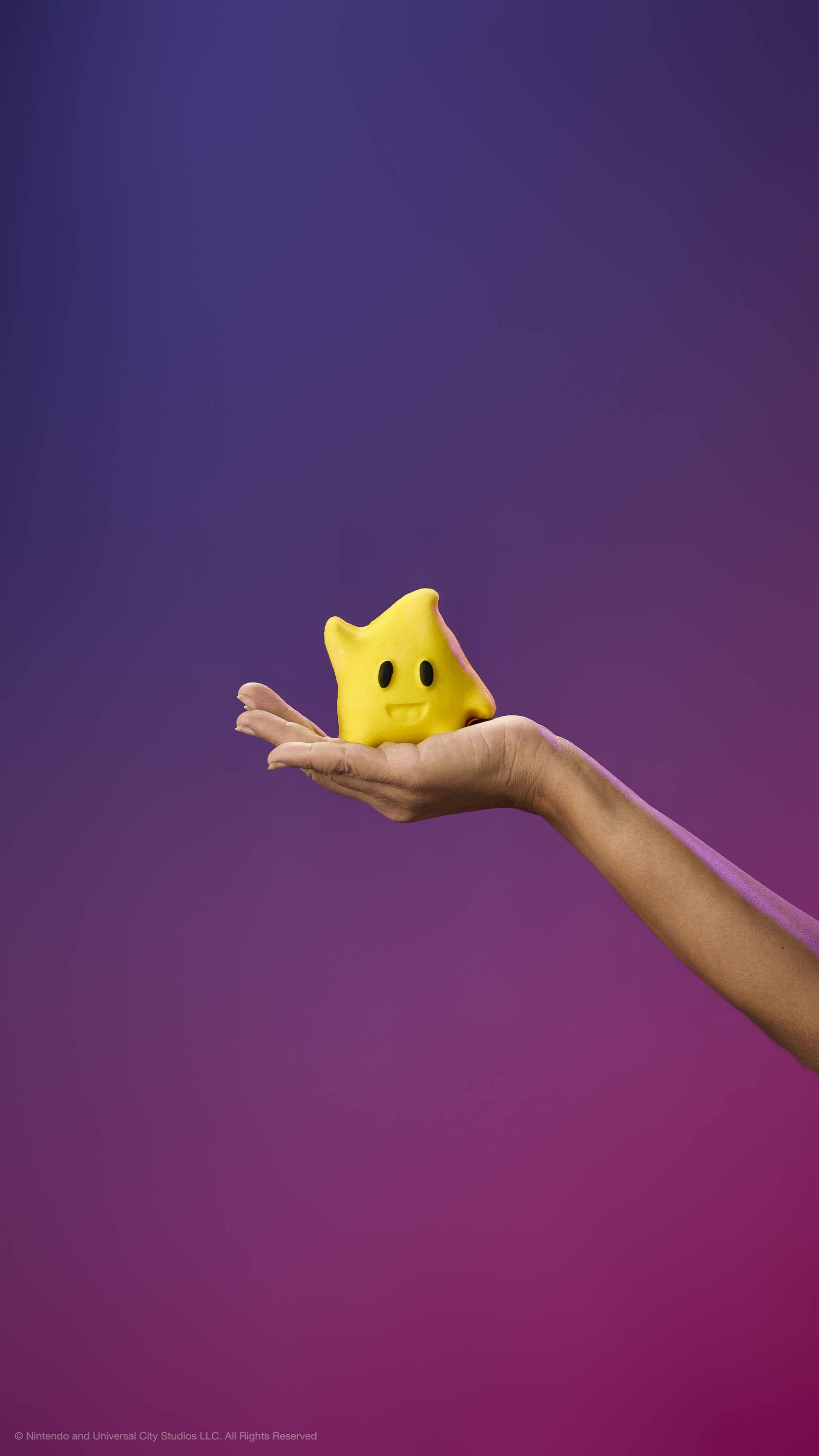 A hand holds a yellow star-shaped character bubble bar with a curl on top, black eyes, and a smile against a purple gradient background.