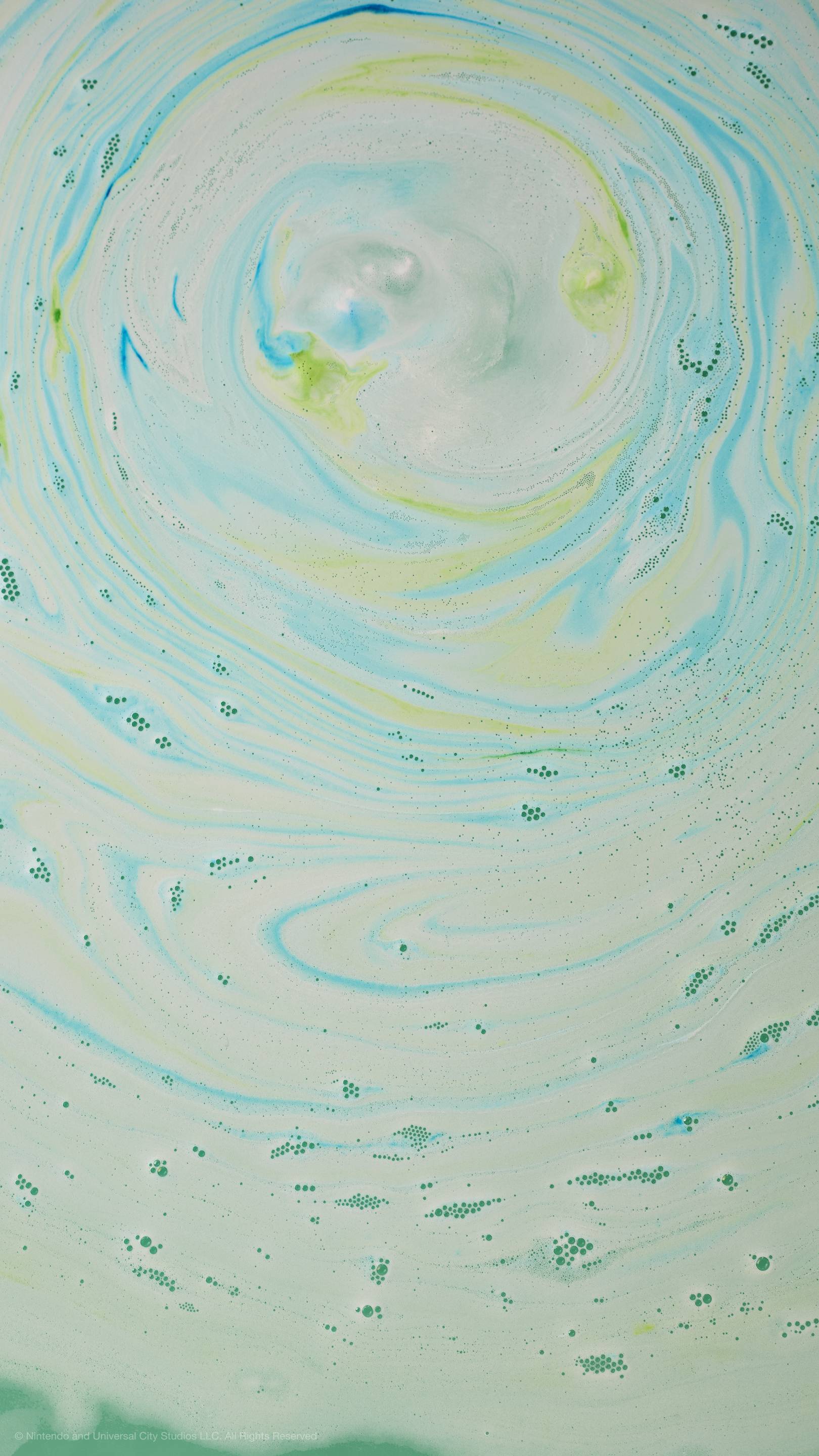 Top-down view of bathwater with swirling patterns of light-green, blue, and white foam and bubbles.