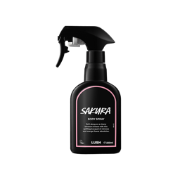 Sakura body spray. A black spray bottle of Lush "Sakura" Body Spray. The product label is black with a pastel-pink banded border. White text states the product name and the scent description.