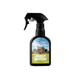 Mossy Bottom. A classic, black recycled plastic, LUSH body spray bottle viewed from the side. The front sticker shows a simple, country home with blue skies and green grass. The text reads "Mossy Bottom" with the LUSH X Shaun The Sheep logo.