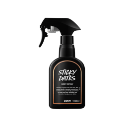 Sticky Dates body spray. A black spray bottle of Lush "Sticky Dates" Body Spray. The product label is black with a light brown banded border. White text states the product name and the scent description.