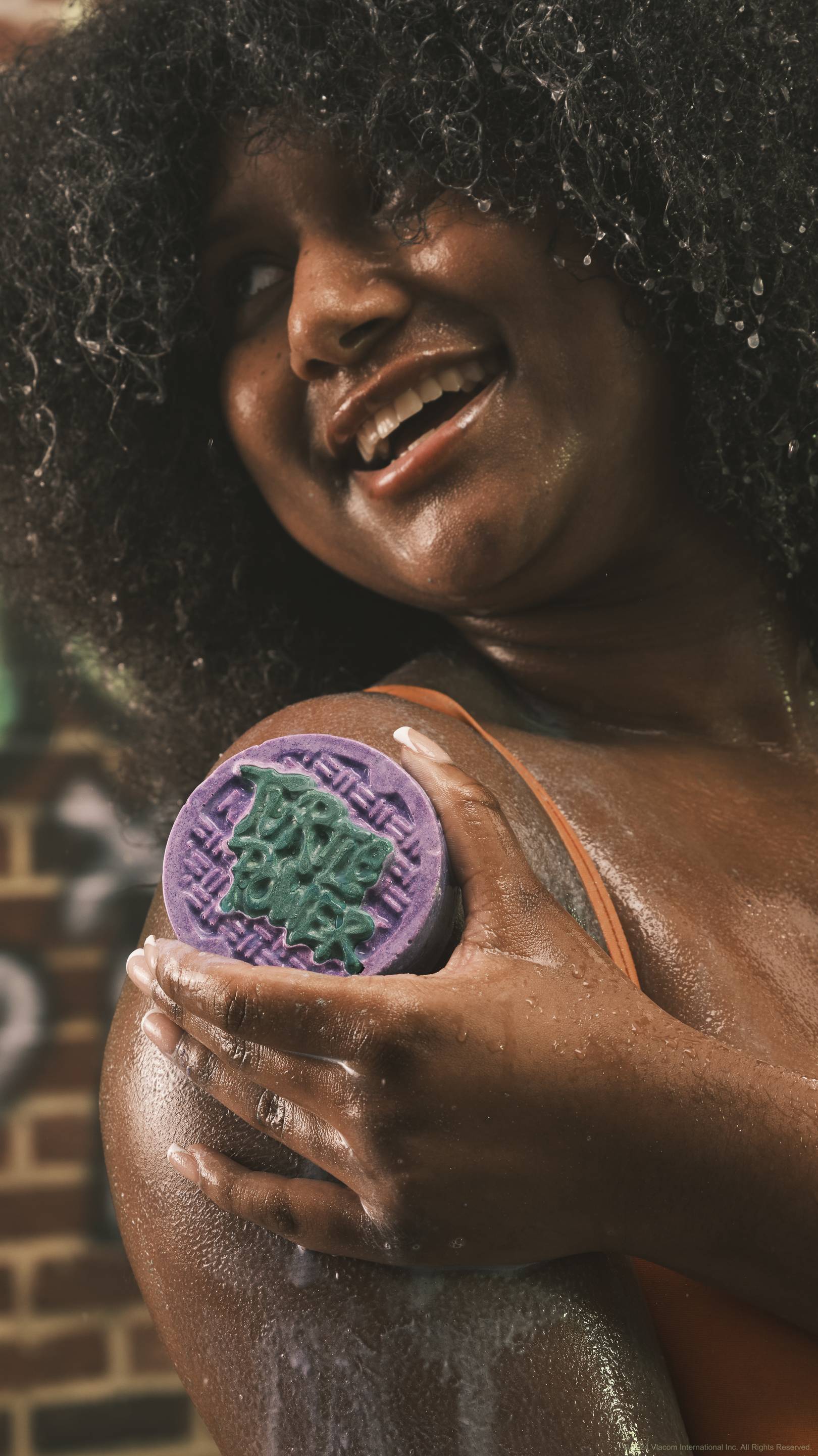 A close-up shot of the model's shoulder which they are lathering up in thick suds with the Turtle Power solid body scrub creating a soft, creamy lacquer. 