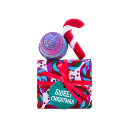 A Lush Sweet Christmas gift set wrapped in vibrant patterned paper with a pink ribbon and teal tag, topped with a purple swirl bath bomb and a red candy cane bubble bar.