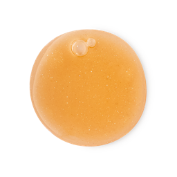Aliento Del Colibrí. A perfectly circular dolloped swatch of semi-translucent, warm orange shower gel filled with subtle golden shimmer and a few small air bubbles.