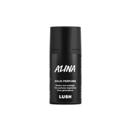 Alina. A short, cylindrical black push-up tube of the Alina solid perfume with a black label on the front covering the cap, with the product name and scent printed on it. 