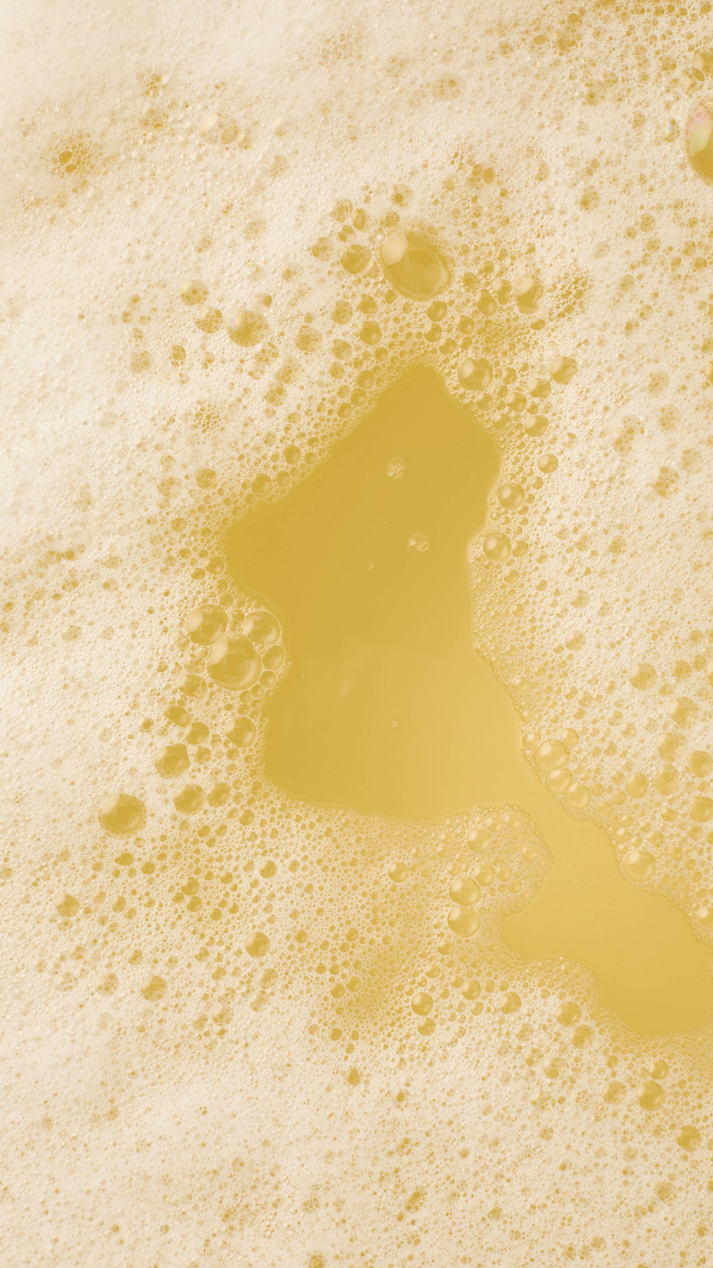 pale yellow bathwater and a thick layer of frothy white bubbles.