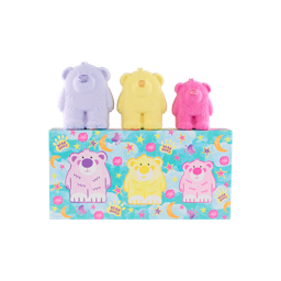 Three bear-shaped bath bombs (purple, yellow, and pink) stand atop a Lush Bear Hugs gift box. The box has colourful bear, star, and moon illustrations, matching the bath bombs in purple, yellow, and pink.
