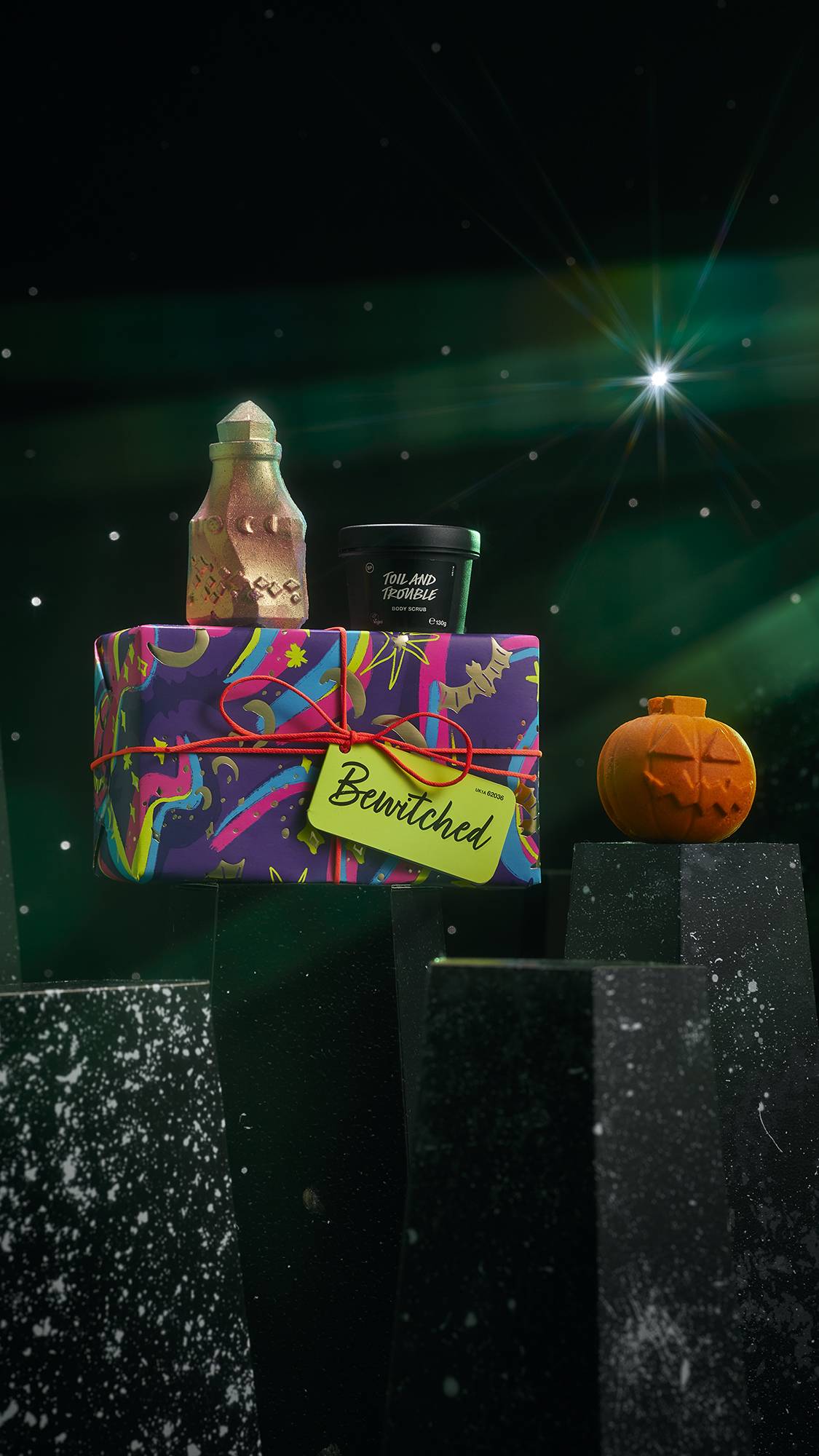 Bewitched gift. Toil and Trouble body scrub, Pumpkin Crumble bubble bar and Magic Potion bath bomb sit atop a colourful box.