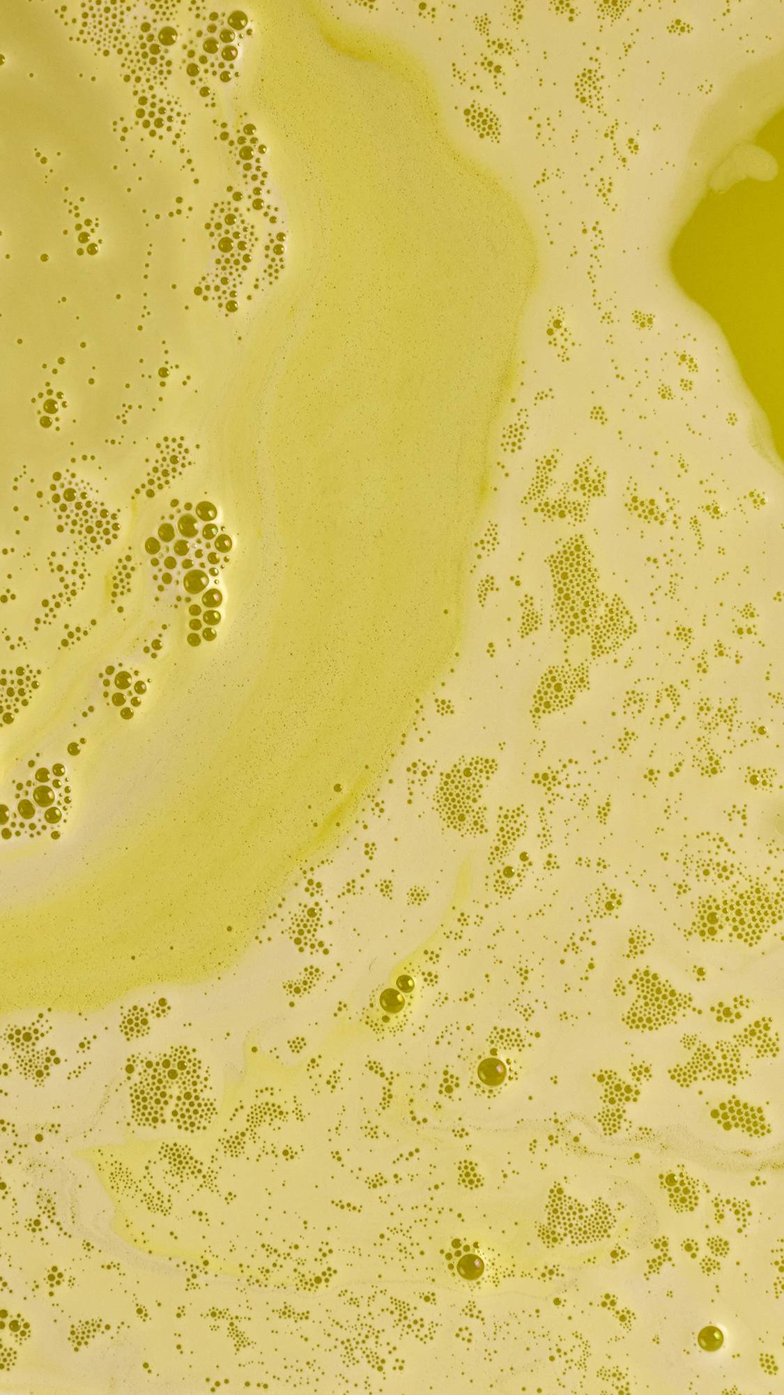 The Blooming Beautiful Marigold bath bomb has dissolved leaving bright yellow, foamy water. 