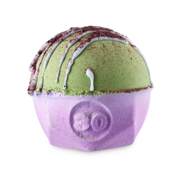 Blueberry Matcha Oat Latte. A spherical bath bomb with a flat, geometric base. The lower half is a pretty, purple colour with the number "30" embossed on the side. The top half is a leaf green colour with a white drizzle and flakes on top. 