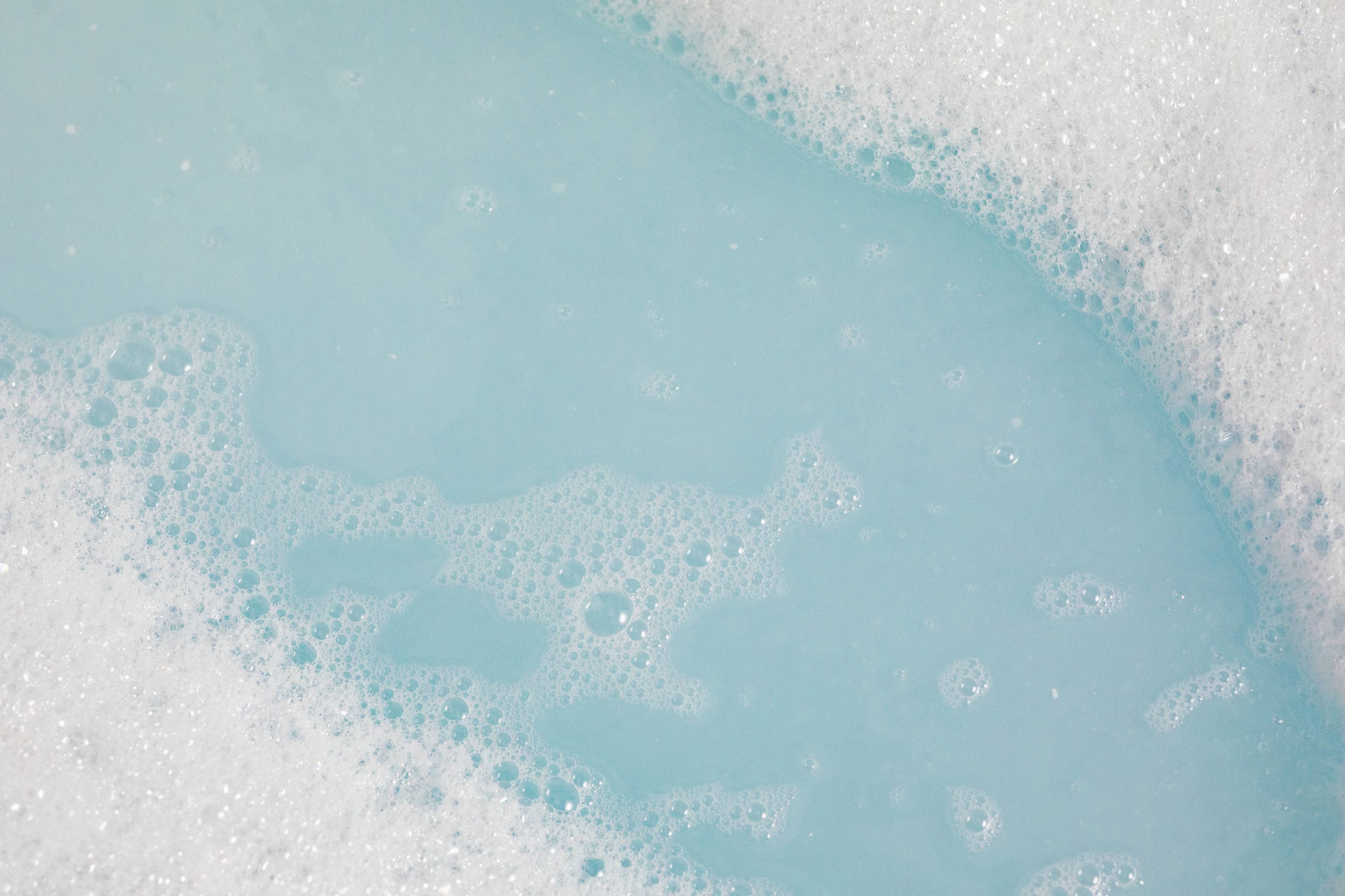 Image shows a close-up of fresh, glacier-blue water surrounded by crisp white bubbles.