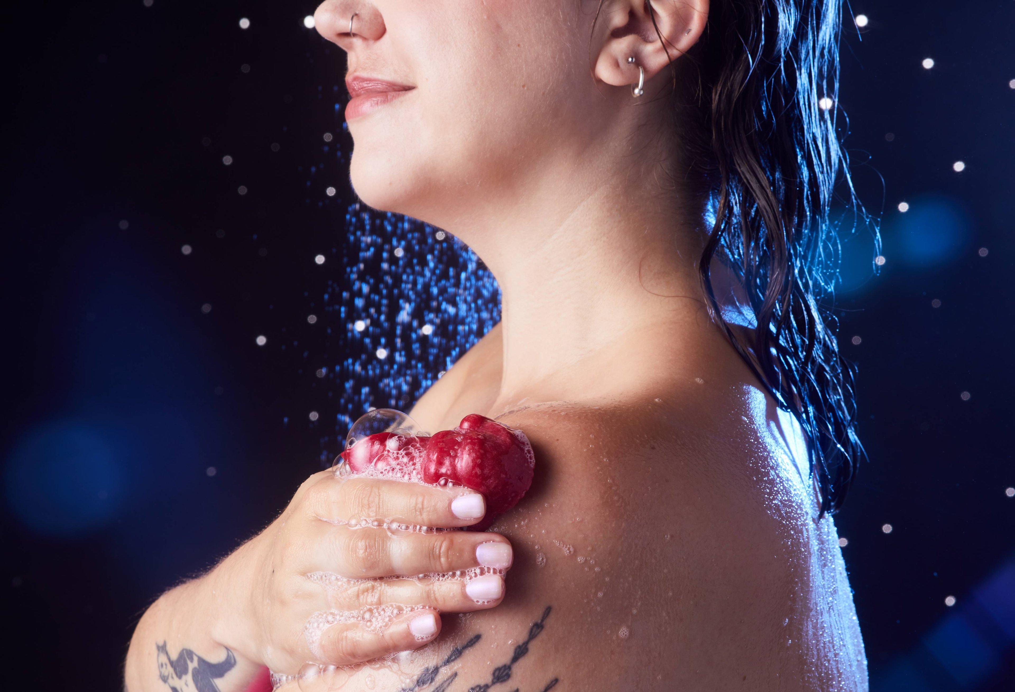 Image shows the model in the shower as they lather up their shoulder with the Bouncing Santa shower jelly. 